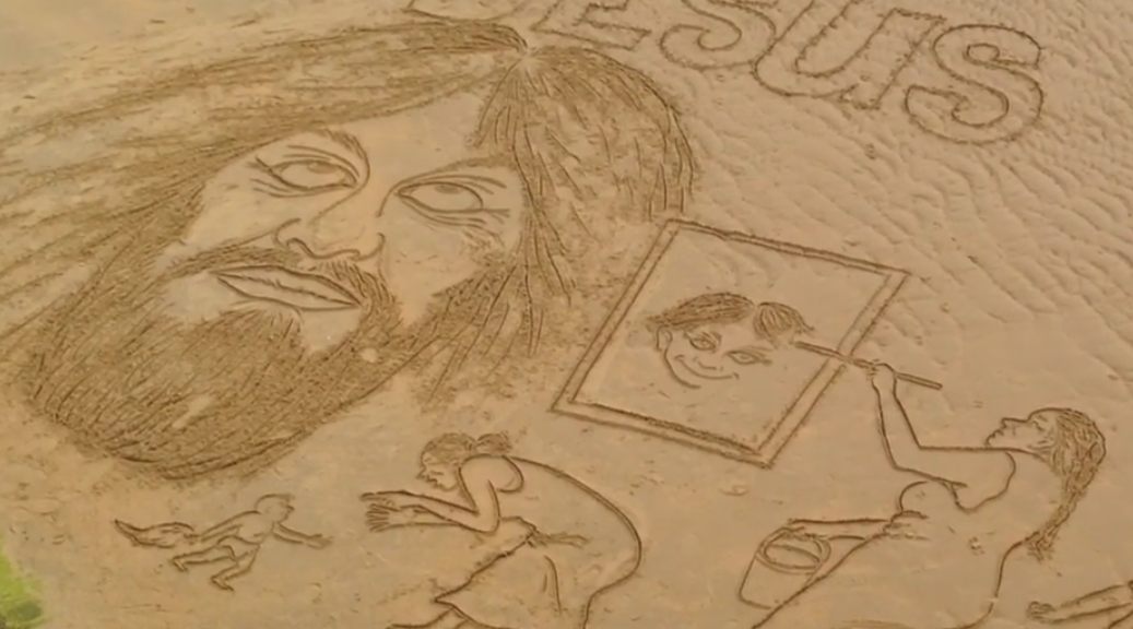 artista dibujando sobre la arena de la playa La Concha de Donostia - San Sebastián
